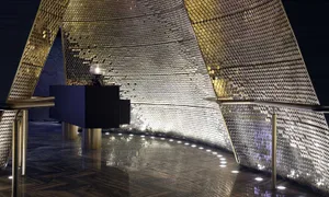 A modern lobby featuring a metallic hexagonal-patterned ceiling.