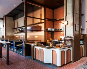 Modern restaurant cafe interior with seating, counter, and display case.