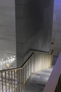 A modern staircase with metal railings and marble steps.