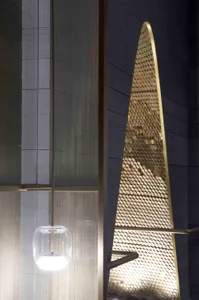 A modern staircase design featuring metallic mesh material.