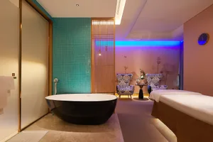 Spa room featuring a modern design with teal tiles and illuminated ceiling lights.