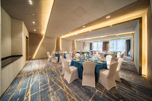 Modern banquet hall with fabric chairs and floating lights