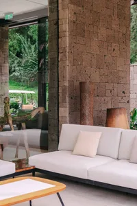 Modern living room with minimalist design featuring concrete walls and furniture.