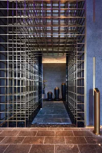 A modern lobby featuring a water feature surrounded by metal railings and stone flooring.