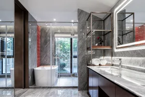 Modern minimalist bathroom with marble finishes, glass shower enclosure, and freestanding bathtub.