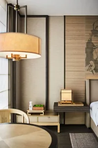 A modern bedroom featuring wooden furniture and lighting.