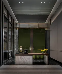 A modern hotel lobby with a marble desk and glass walls.