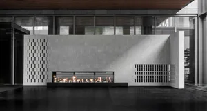 A modern interior with a concrete fireplace emitting flames.