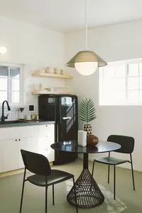 Modern minimalist kitchen featuring concrete countertops and metal furniture.