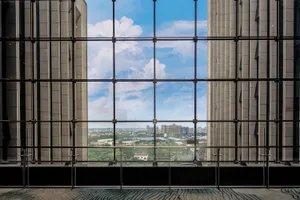High-rise building with panoramic cityscape view through glass windows.