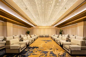 An interior image of an event hall with sofas arranged in rows.