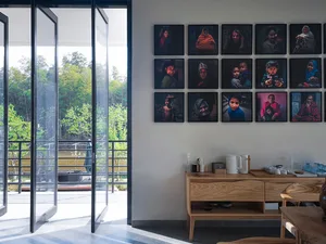 A minimalist bedroom with portraits of a family hanging on the wall.