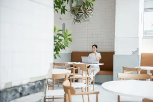 A minimalist cafe interior features clean lines, white walls, and a mix of materials, including wood and concrete.