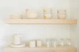 A minimalist kitchen featuring handcrafted ceramic dishes and utensils.