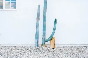 A minimalist landscape featuring a white wall, concrete base, and gravel ground.