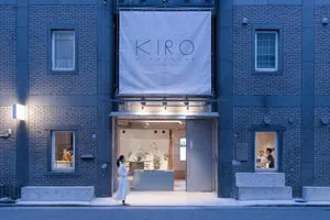 Modern election office entrance with a concrete facade and a sign reading 'Kiro Hiroshima'.