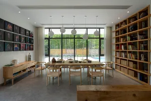 A modern living room with wooden furnishings and a large window.