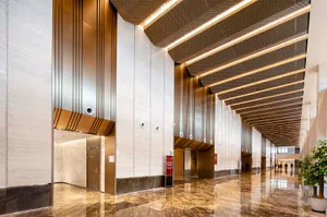 Modern design features marble, metal, and glass materials in a corporate lobby.