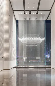 A modern minimalist lobby featuring glass elements and a reflective floor.