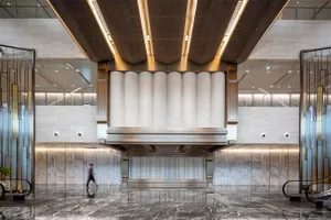 Modern office lobby featuring marble, concrete, and metallic finishes.