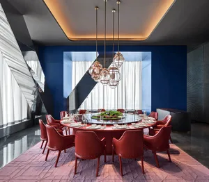 A modern dining room with red leather chairs, a round table, and a large window.