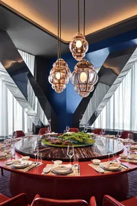 Modern restaurant interior with glass lighting fixtures and a marble dining table.