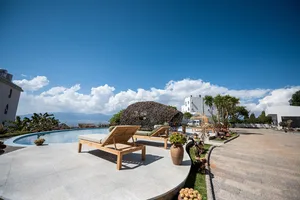 A serene poolside landscape featuring wooden loungers, concrete steps, and glass decorations.