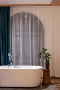Modern minimalist bathroom with a white bathtub and wooden frame