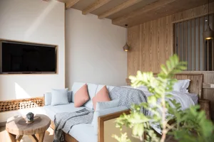 Modern minimalist living room featuring wooden furniture and decor, creating a cozy and inviting atmosphere.