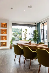 Modern dining room featuring a wooden table and green chairs with a view of the outdoors.