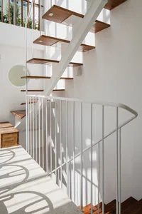 A modern staircase with concrete steps, steel railings, and wooden treads.