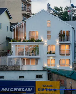 A white-paneled building with large windows and balconies.