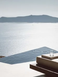 A minimalist holiday villa with a concrete structure and a view of the serene sea.