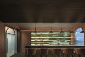 Modern bar interior featuring metallic shelves and light fixtures.