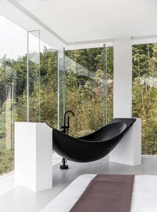 Modern bathroom with a black bathtub, white walls, and glass enclosure