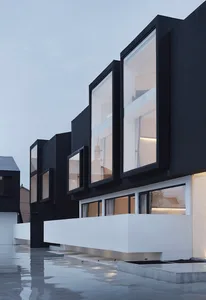 A modern, black building features striking concrete exterior with large windows.
