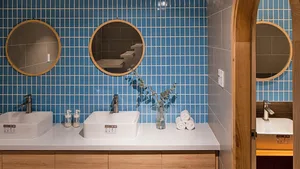 Modern bathroom with blue tiles and wooden countertop