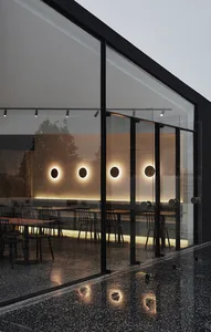 A modern coffee shop featuring glass walls and concrete flooring.