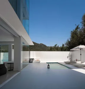 Modern architectural exterior featuring glass walls and concrete pool.