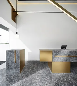 A modern industrial office front desk made of concrete and gold, featuring clean lines and minimalist design.