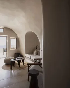 Contemporary living room featuring a minimalist design with concrete walls and a cozy seating area.