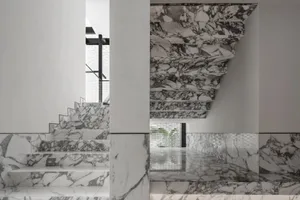 A staircase with marble steps and walls in a modern interior.