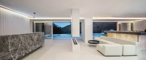 Modern living room with marble accents, overlooking a scenic outdoor view.