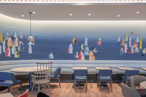 A modern restaurant interior featuring a colorful fish wall art mural.