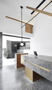 Modern retail cafe interior with a concrete and terrazzo counter featuring brass accents.