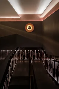 Modern staircase featuring illuminated metal railings and steps.