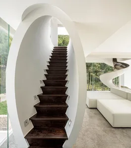 A modern interior featuring dark wooden stairs with white walls and floors.