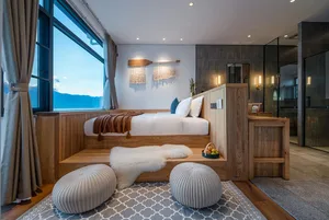 Minimalist bedroom with wooden furniture, white bedding, and grey rug.