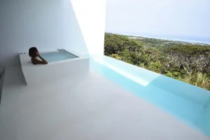 現代泡湯池搭配玻璃圍護，提供壯麗的景觀與遠方海洋景色。