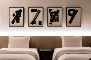 Minimalist bedroom with black numbers on the wall and soft, neutral bedding.